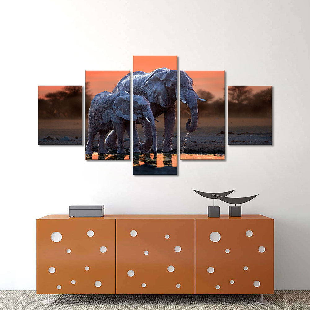 Elephant walking with baby in sunset canvas wall art